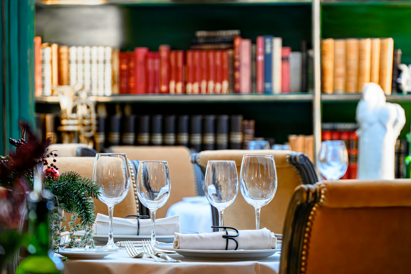 Un tavolo da pranzo formale apparecchiato con piatti bianchi e bicchieri da vino.